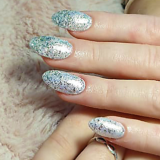 Hand with long oval nails painted in silver glitter polish.