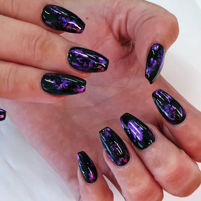 Coffin nails in black gel with purple foil accents.