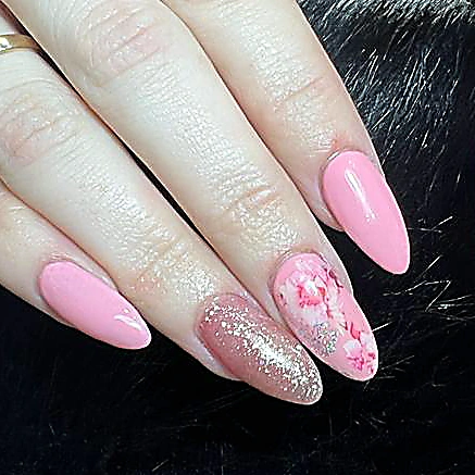 Almond nails in soft pink with a glitter accent nail and a floral design.